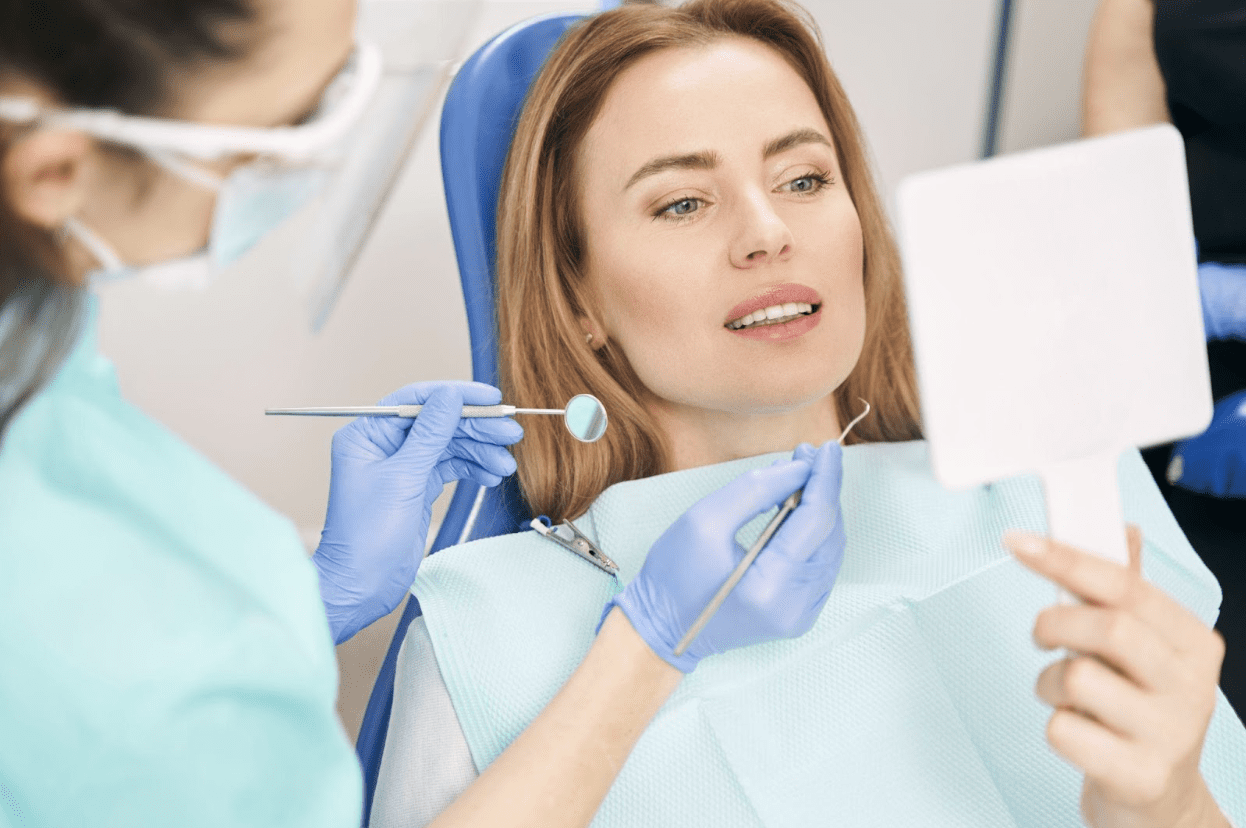 patient at the dentist looking at her teeth in the mirror