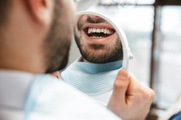 Patient smiling in the mirror with dental implants