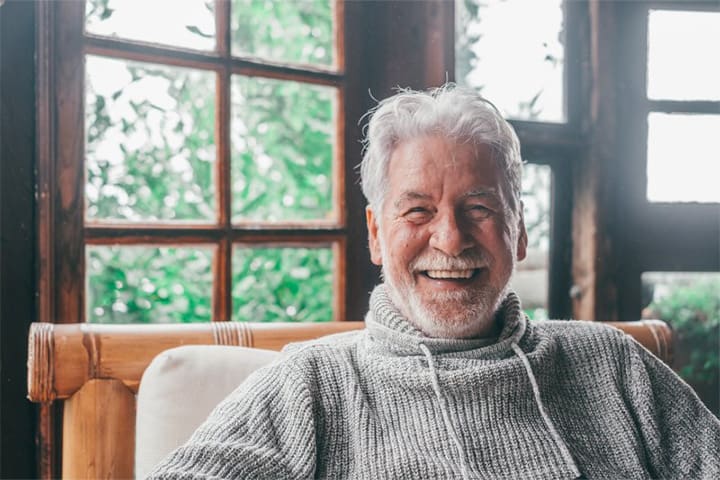 Man sitting in his cozy cabin and smiling