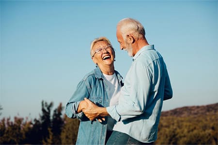 Senior couple laughing outdoors