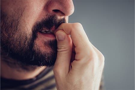 Closeup of man biting his nails