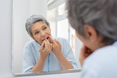 Woman flossing in bathroom