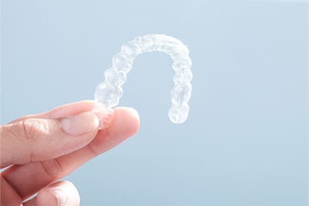 Patient holding clear aligner.