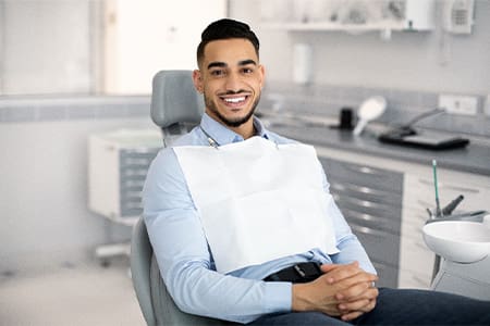 Patient smiling while sitting in treatment chair.