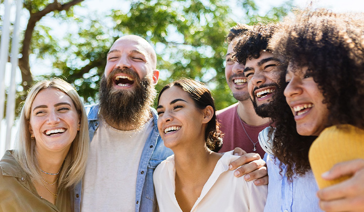 Patient in Weston smiling with friends after dental crown treatment.